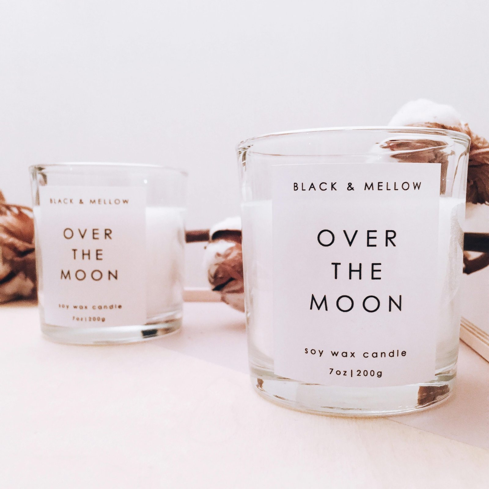 Soy candles in glass containers, labeled 'Over The Moon', with cotton accents for a classy home decor.